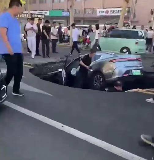 邯郸柏油马路突现深坑，有车辆猝不及防陷落，车主踩着车身从坑内爬出