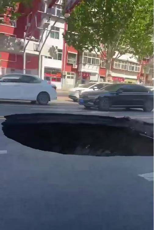 邯郸柏油马路突现深坑，有车辆猝不及防陷落，车主踩着车身从坑内爬出
